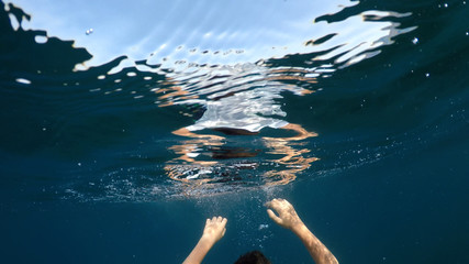 young man sinking into the sea