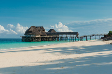 Obraz premium beautiful wooden pier with thatched huts in ocean