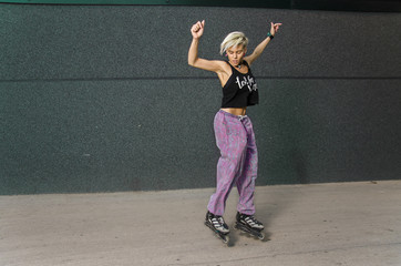 Roller skater girl jumping, black wall background 
