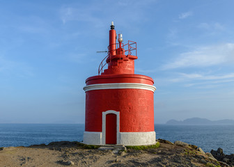 red lighthouse on the background of the ocean
