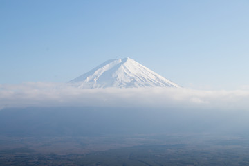 Mount Fuji that is the famous landmark in Japan with white cloud on blue sky background