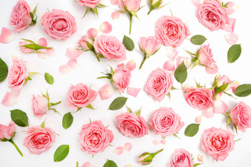 Floral pattern made of pink roses, green leaves, branches on white background. Flat lay, top view. Floral pattern.