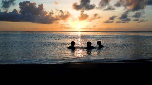 amis qui se baignent au coucher du soleil 