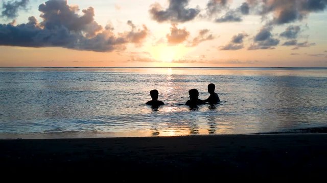 amis qui se baignent au coucher du soleil 