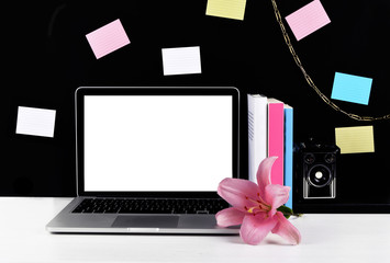 Stylish workspace with laptop, camera, sticky notes.