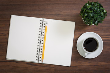 View from above with copy space office table , notebook with cup of coffee and Tree vases