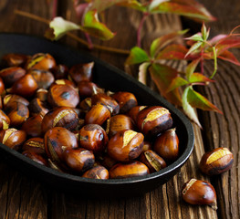 Roasted chestnuts on an old board. Selective focus.