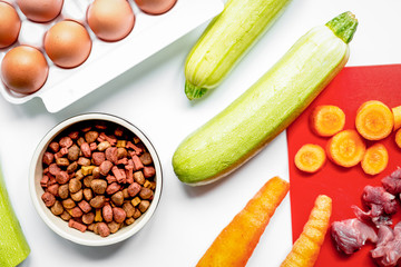 healthy dogfood with eggs, vegetables and meat on kitchen backgr