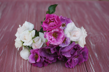 Bouquet of pink and purple garden roses on a wooden background