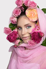 Studio portrait of a beautiful young woman. Fashionable brunette model with nude pink lips and perfect colorfull makeup in scarf on head