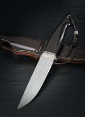 hunting knife handmade on a brown wooden background. Leather Sheath Handmade