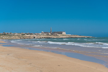 Langer Sandstrand mit blauem Himmel am Mittelmeer