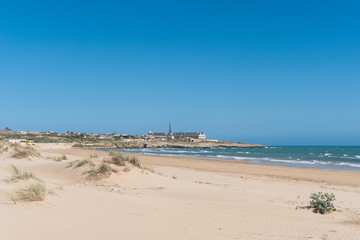 Strand am Mittelmeer mit D&uuml;nen und einer Ruine im Hintergraund