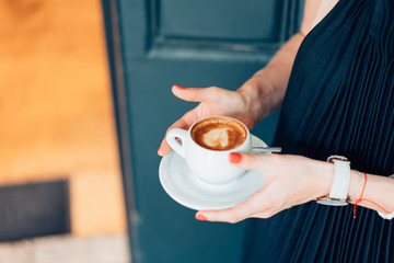 woman holding hot cup of coffee