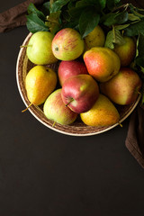 Plate with ripe pears and apples. Low key. Selective focus
