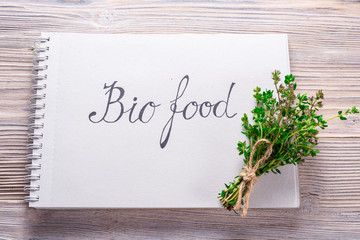 Letters Bio Food on notebook on wood background