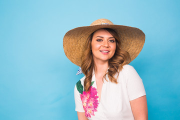 Holidays, summer, fashion and people concept - Girl in fashionable clothes straw hat. Portrait of charming woman on blue background with empty copy space