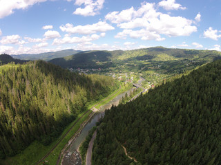 Fototapeta na wymiar Aerial view of the river near the mountain road with bridge