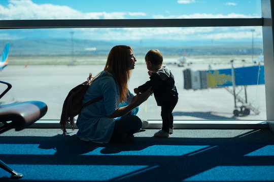 Little boy and his mother sitting in an airport
