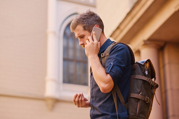 A man speaking by smart phone in an old European town.