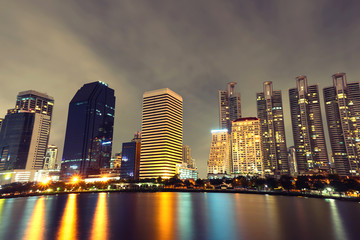 Naklejka premium Bangkok thailand cityscape with water reflection at blue night sky