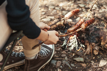 Obraz premium Camping in the wild - Grilled sausages above the campfire
