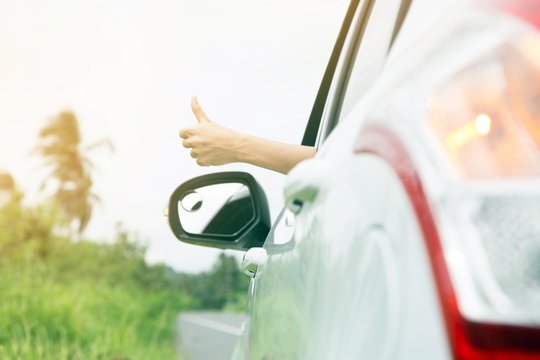 Atmosphere air is refreshing in the sunshine. Young woman hand show thumbs up Drive out on the road on holiday.