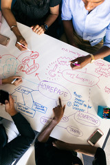 Workspace: Overhead View Of Team Brainstorming Tech Plans