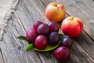 Ripe plums, nectarines and apples on a wooden table