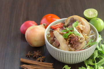 Oxtail soup, halal food, delicious, Muslim food in green bowl on dark brown wooden plate / Selective focus.