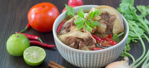 Oxtail soup, halal food, delicious, Muslim food in green bowl on dark brown wooden plate / Selective focus.