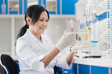 Positive joyful chemist holding test tubes