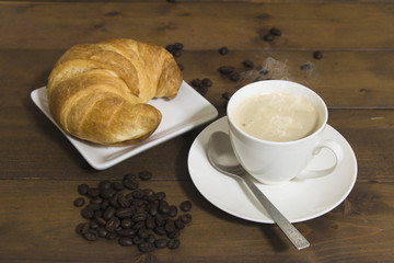 coffee and croissant on wooden