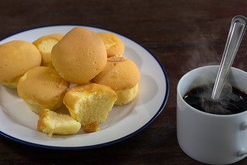 Butter cupcake and black coffee on old brown wooden / Selective focus image.