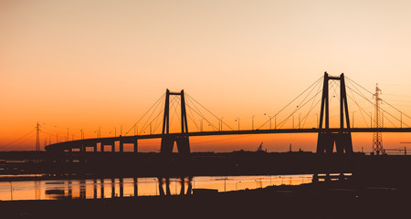 Fototapeta na wymiar Silhouette of the suspension concrete bridge on a sunset