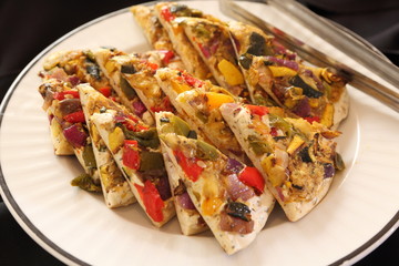 Mini Pizza slices with vegetables on flatbread on plate