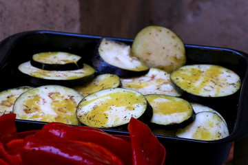 Slices of eggplant and red pepper with spices, ready for grill. Selective focus.