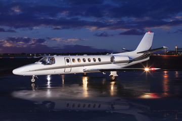 Private Jet on Wet Runway At Sunrise