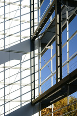 Außengerüst wirft Schatten  / Die moderne Fassade eines öffentlichen Gebäudes mit einem begehbaren Außengerüst welches Schatten wirft.