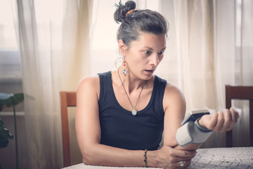 Young woman measuring blood pressure at home
