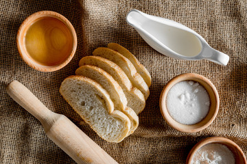 Homemade bread. Slices and ngredients on canvas background top view