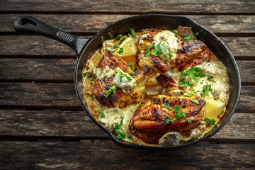 Creamy chicken fellets supremes in mushroom sauce with parsley In rustic cast iron skillet.