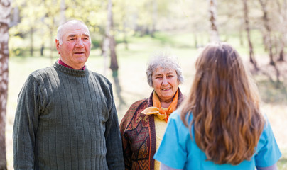 Elderly couple and young caregiver