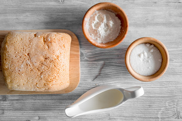 Make bread. Loaf and ingredients on light woden table background top view