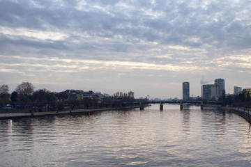 View of main river and cityscape of Frankfurt at dusk.