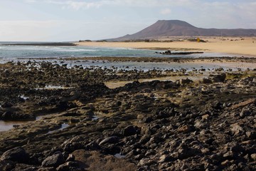 Panoramic ocean view. Volcano, black rocks. Sand macro. Sea background. Horizon.