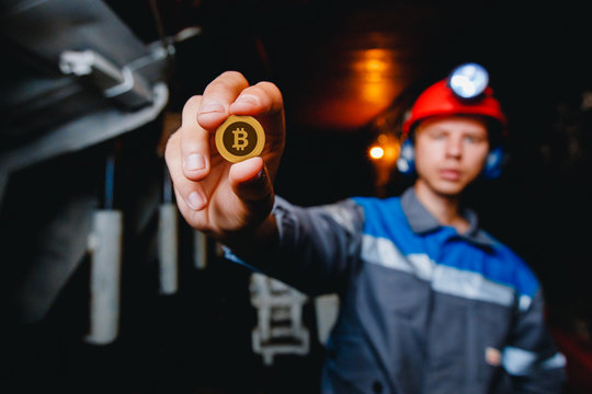 miner in a mine holds a bit of crycoin in his hand. Concept mining crypto currency of ETH Ethereum.