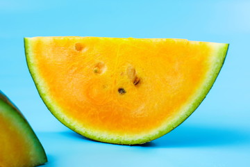 Yellow watermelon slice against blue background