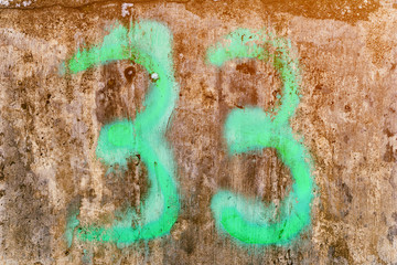 the number 33 painted in glowing neon green on concrete