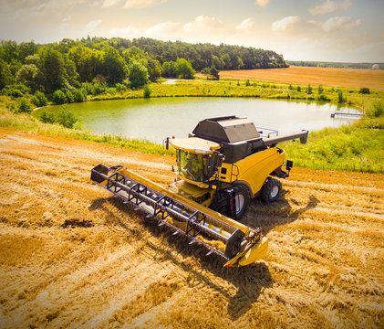 Aerial view of combine harvester. Harvest of wheat field. Czech rural landscape in summer. Biofuel production from above. Agriculture and environment in European Union. 
